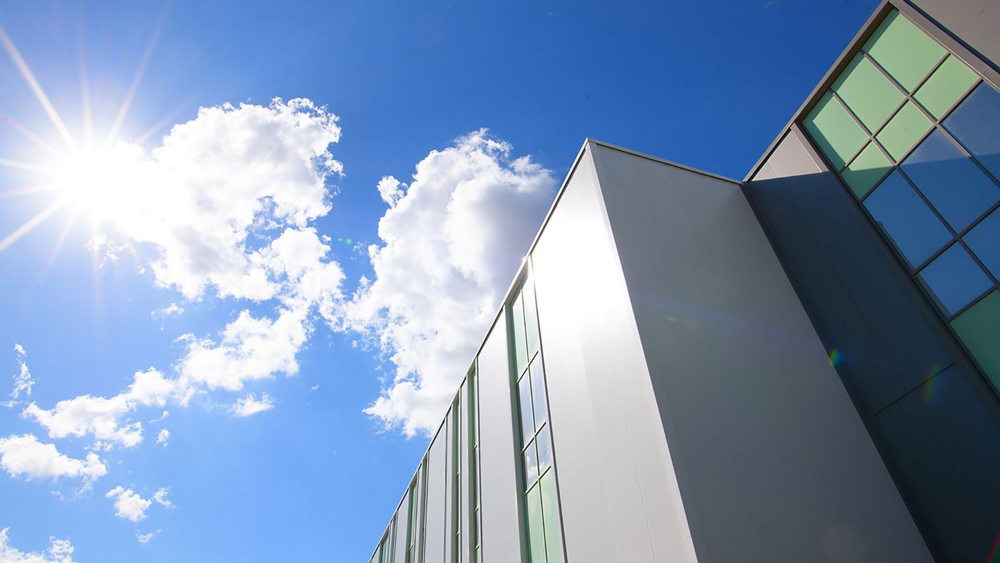 ELPEN building facade with glass panels against a bright blue sky